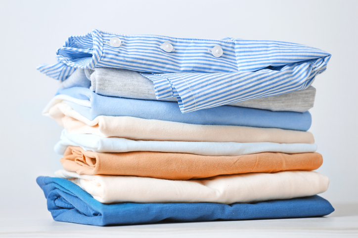 Stack of colorful cotton clothes. Heap of folded laundry.